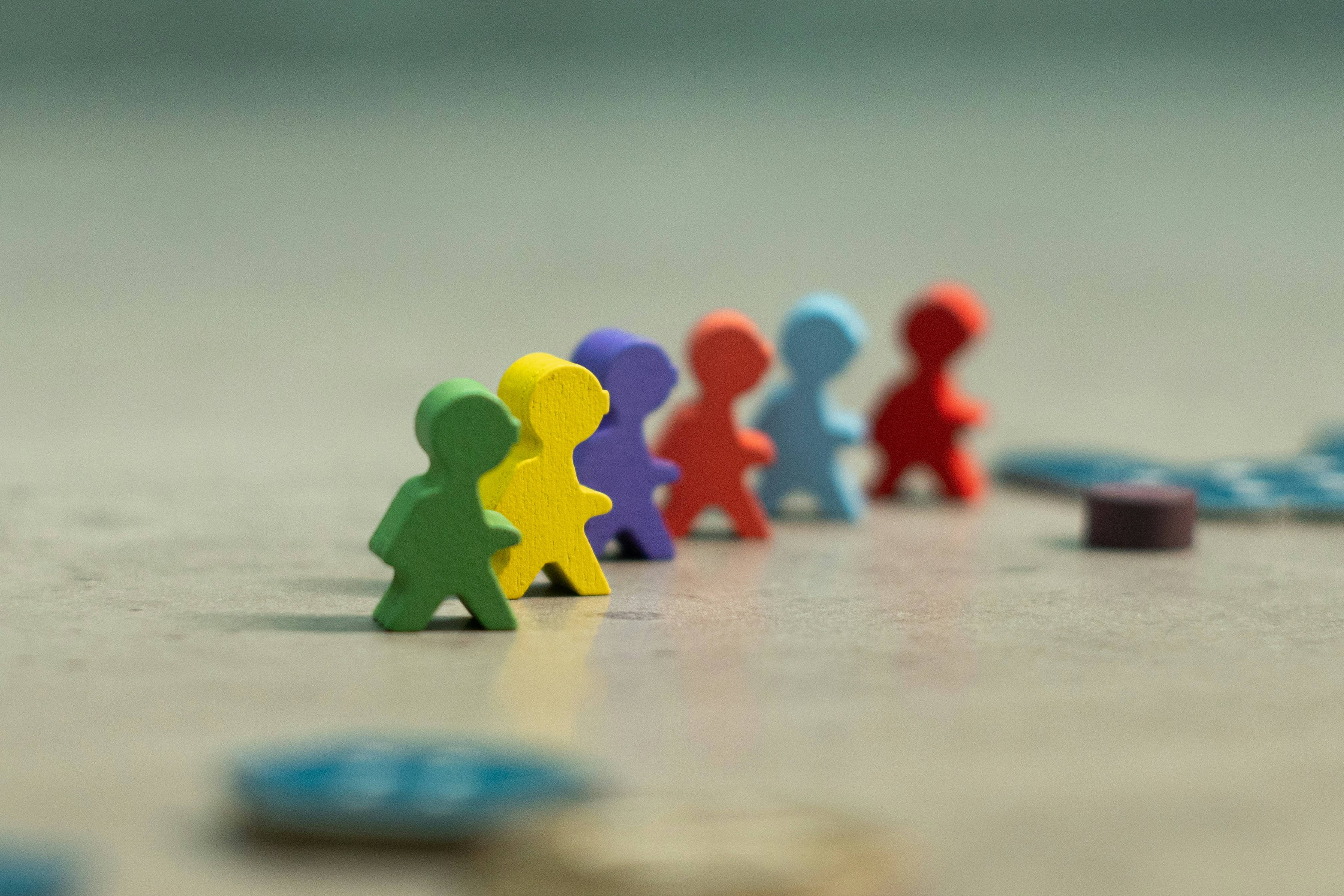 Colorful wooden game pieces representing gamification and team engagement in corporate environments